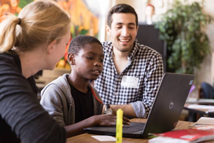 Sam Sadeh ’18 teaches a child how to code as part of funding made possible by Google.