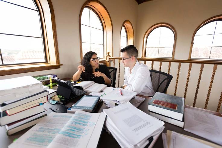 Josie Balzac-Arroyo works with her student on original research in the Olin Library.