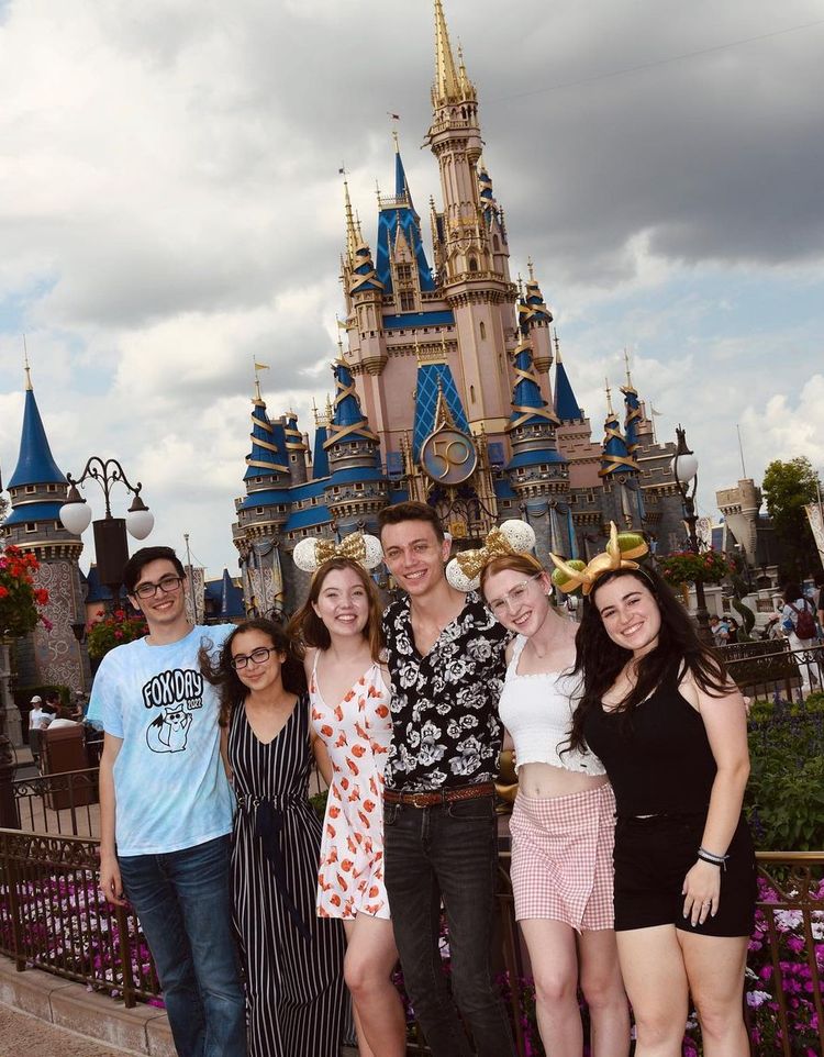 Rollins students stand arm in arm in front of Walt Disney World's Cinderella castle