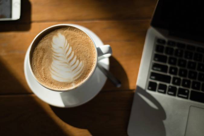 Cup of coffee next to a laptop at Barnie’s CoffeeKitchen on Park Avenue.