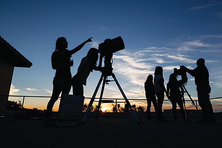 Rollins students looking at the night sky through telescopes as part of their astronomy coursework.