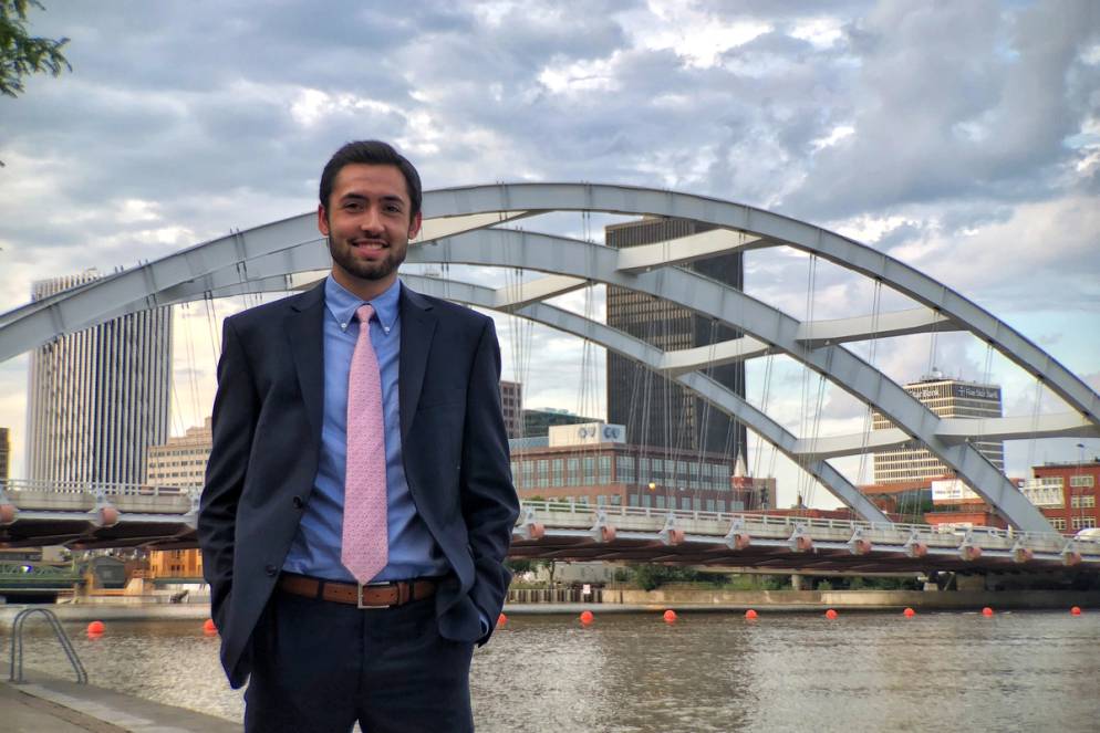 A student poses in front of a bridge in Rochester, New York.