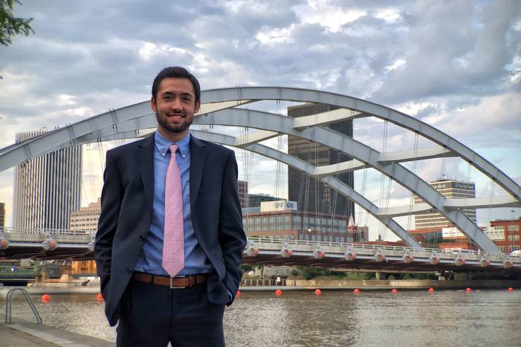 A student poses in front of a bridge in Rochester, New York.