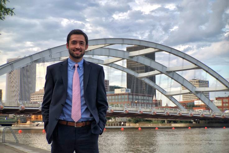 A student poses in front of a bridge in Rochester, New York.