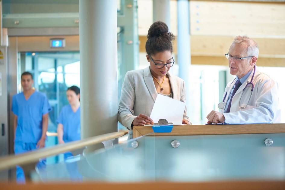 A public health professional meets with a doctor in a hospital.