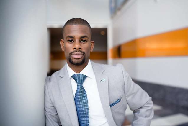 A Rollins College alumn dressed in a suit looking at the camera.