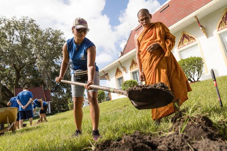 Student digging a hole for a new planting at a local Hindu temple for SPARC Day, Rollins’ annual day of service.