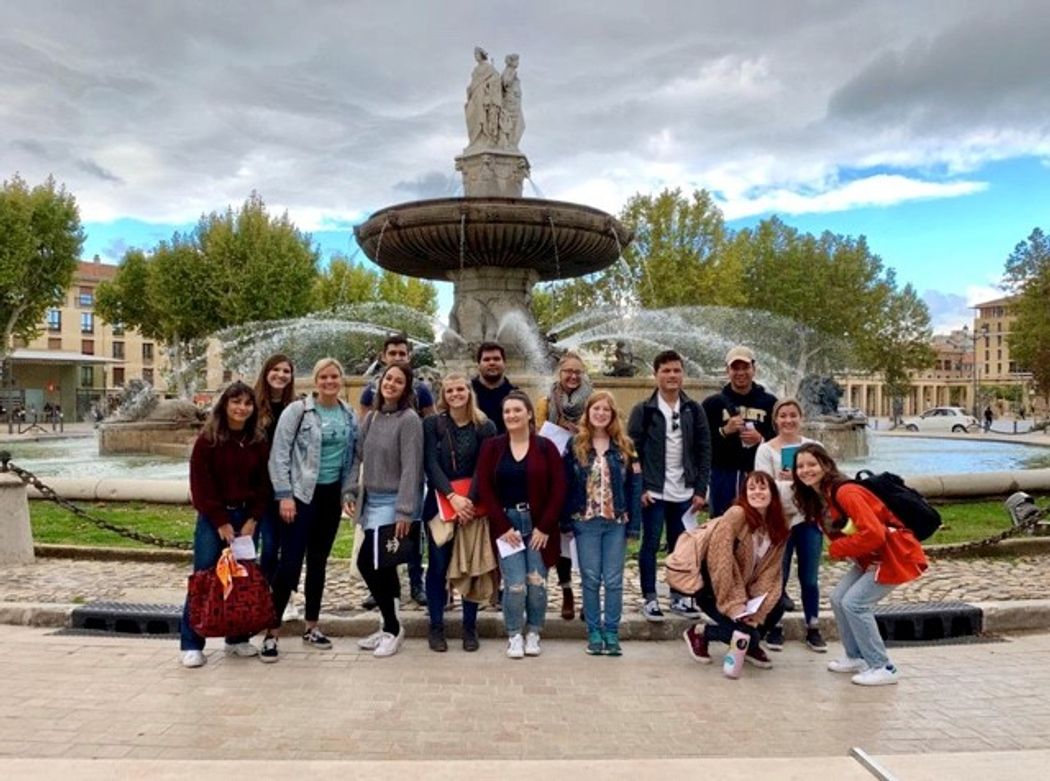 Rollins students and other study abroad students pose in front of the Aix-en-Provence fountain