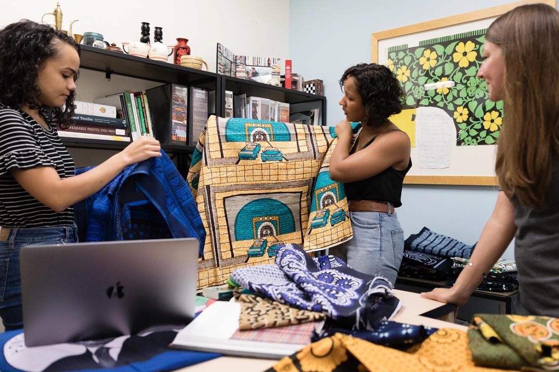 Students examining textiles to include in their exhibition.