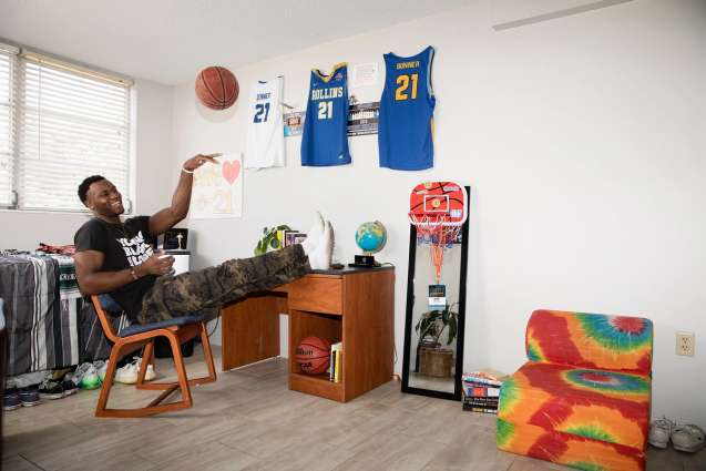 A player on the basketball team shooting a basketball in his dorm room.