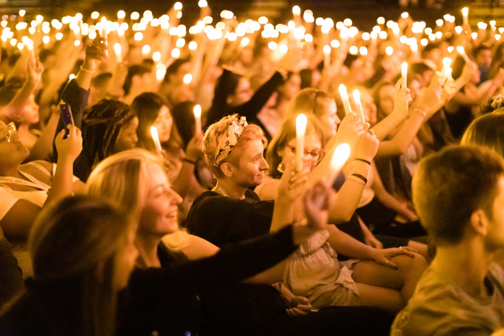 Students hold up candles during the annual Candlewish ceremony.