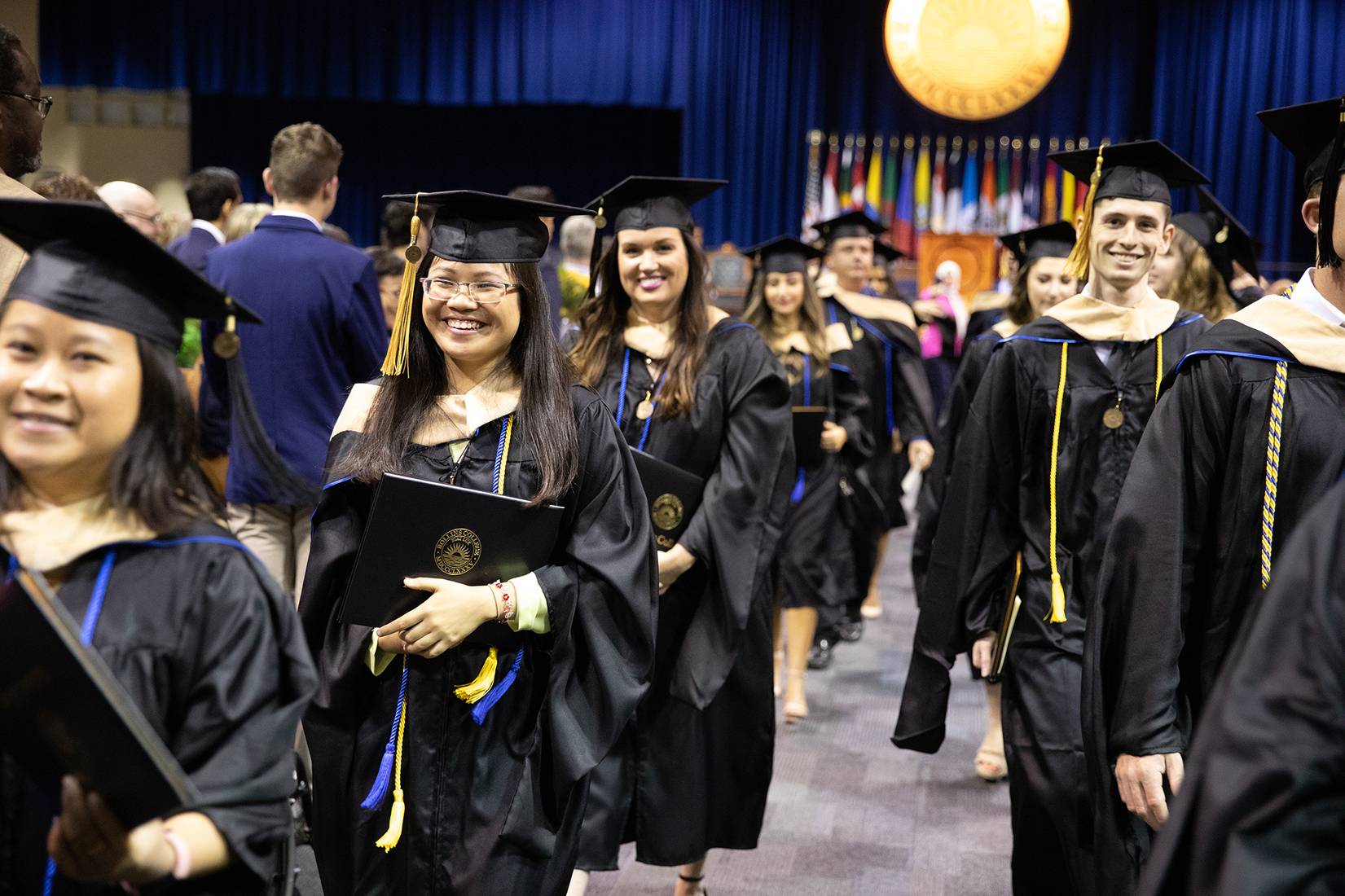 Students in caps and gowns at Crummer Graduate School of Business commencement ceremony.