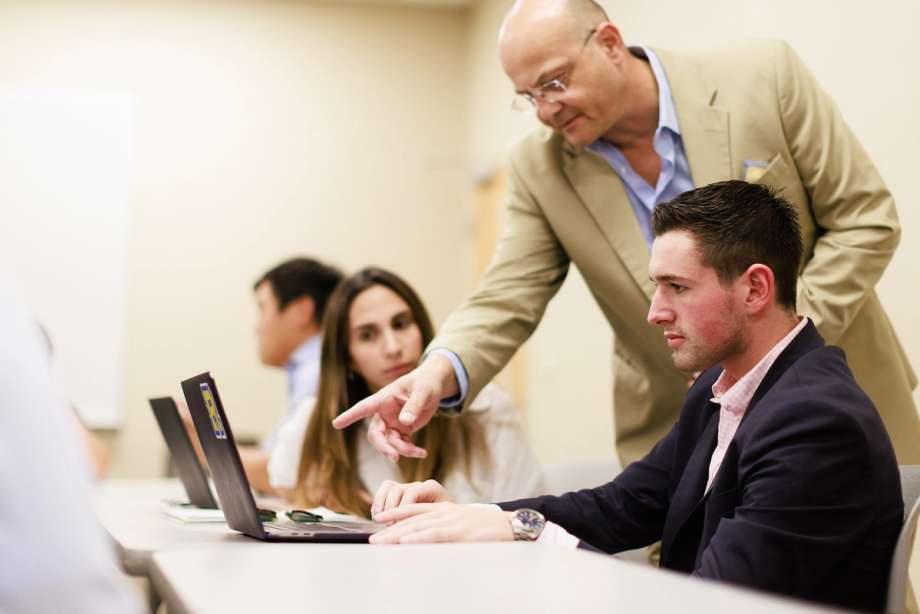 A college professor works one on one with a student during class.