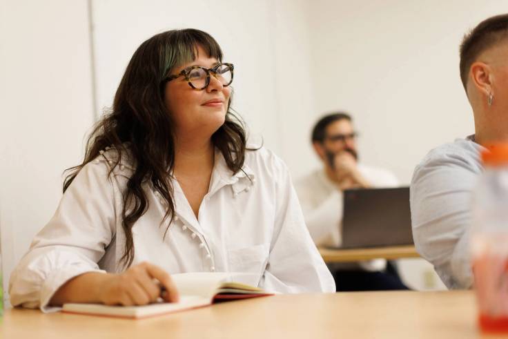 A psychology student smiles at her professor during class.
