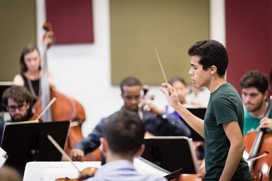 Student conductor practicing with the Rollins orchestra