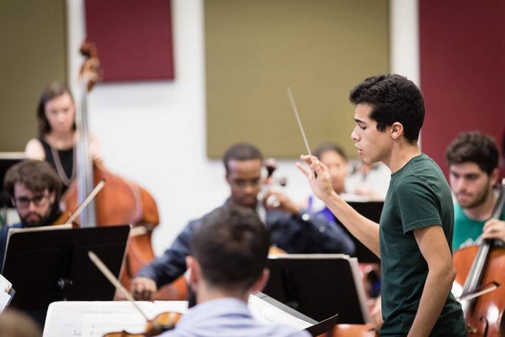 Student conductor practicing with the Rollins orchestra