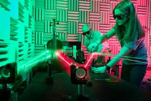 Physics professor and student work with lasers in Rollins’ anechoic chamber.