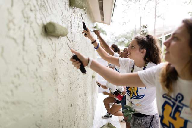 Liberal Arts college students serving others by painting a local school.