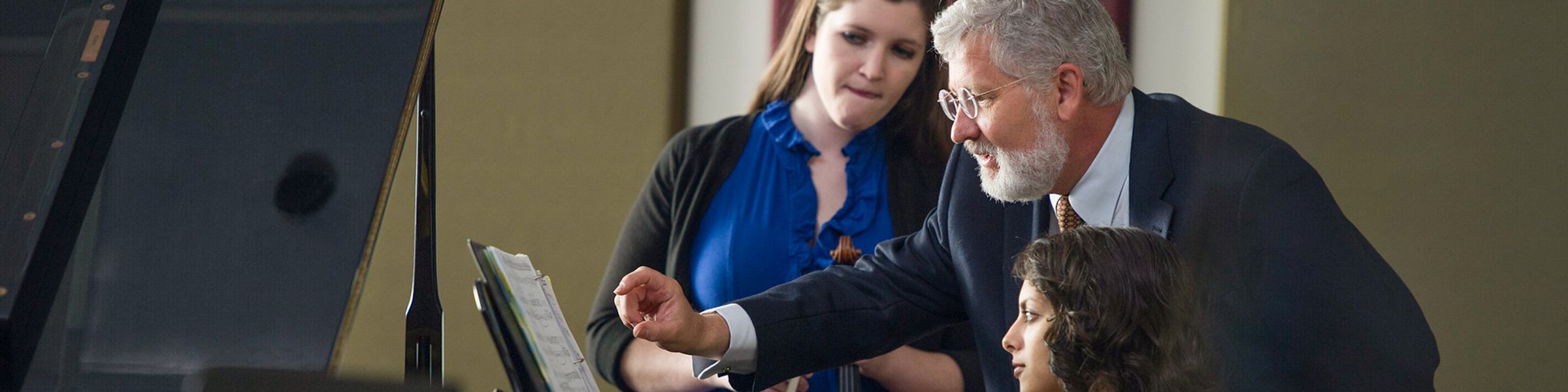 Rollins music professor John Sinclair instructs students at a piano.