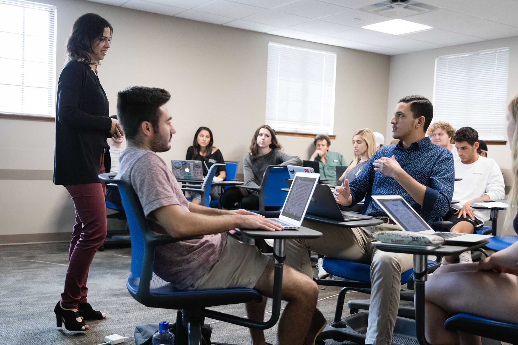 A students discusses a business topic with his professor.