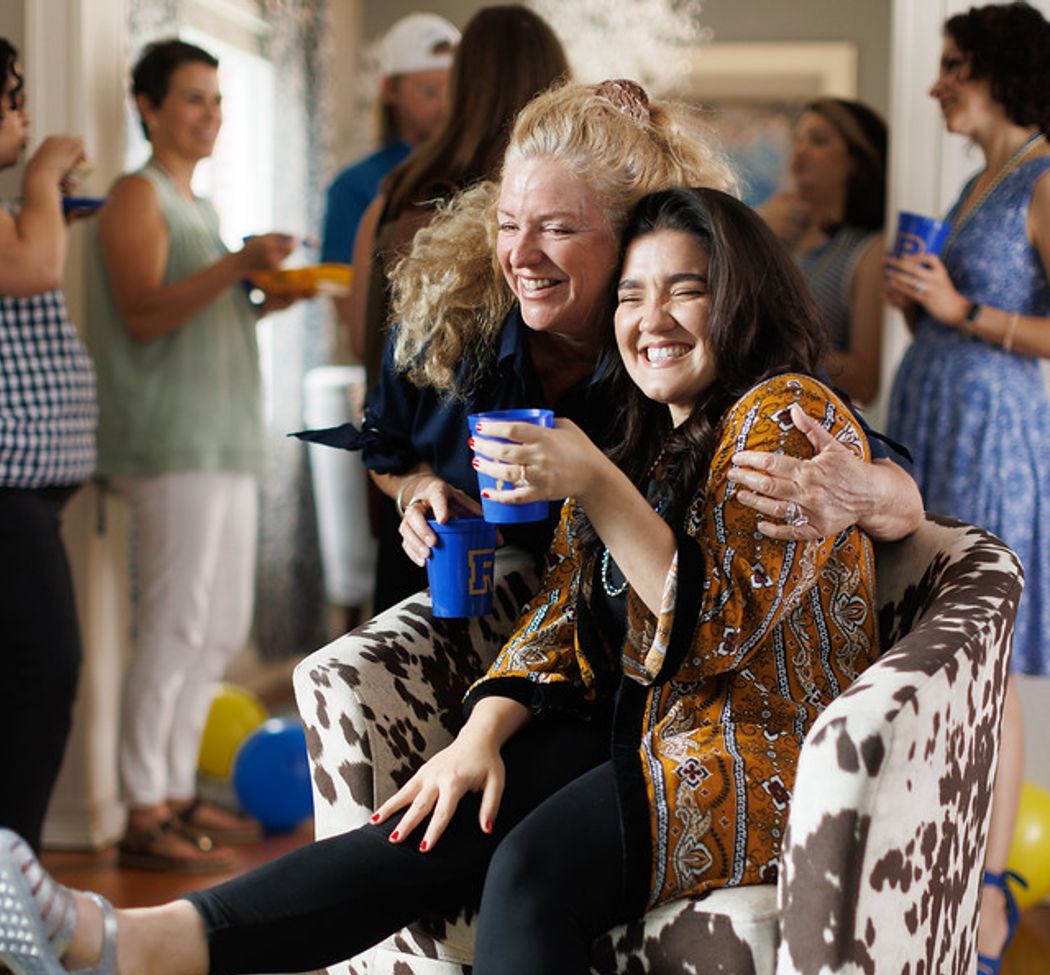 Two alumni hugging at Rollins in a Box party.