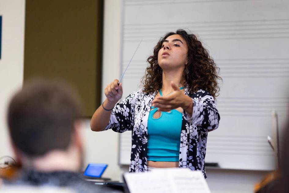 A music student leads the class in a choral conducting lesson.