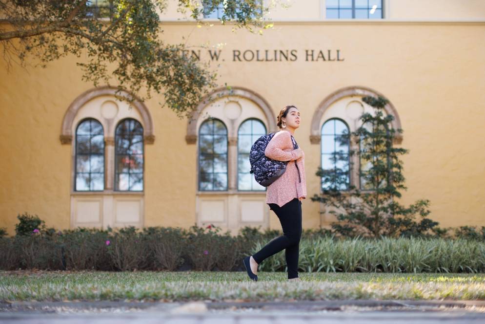 Angelia Rivera ’23 walking by Kathleen W. Rollins Hall.