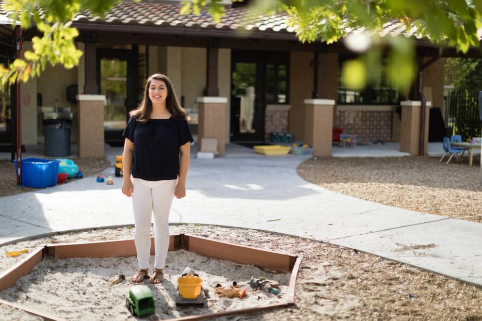 Alexandria Tomkunas ’18 sits on the edge of a sandbox