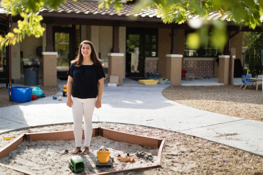 Alexandria Tomkunas ’18 sits on the edge of a sandbox