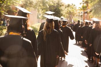 Students in gaps and gowns walk to commencement at Rollins College, one of the best colleges for transfer students.