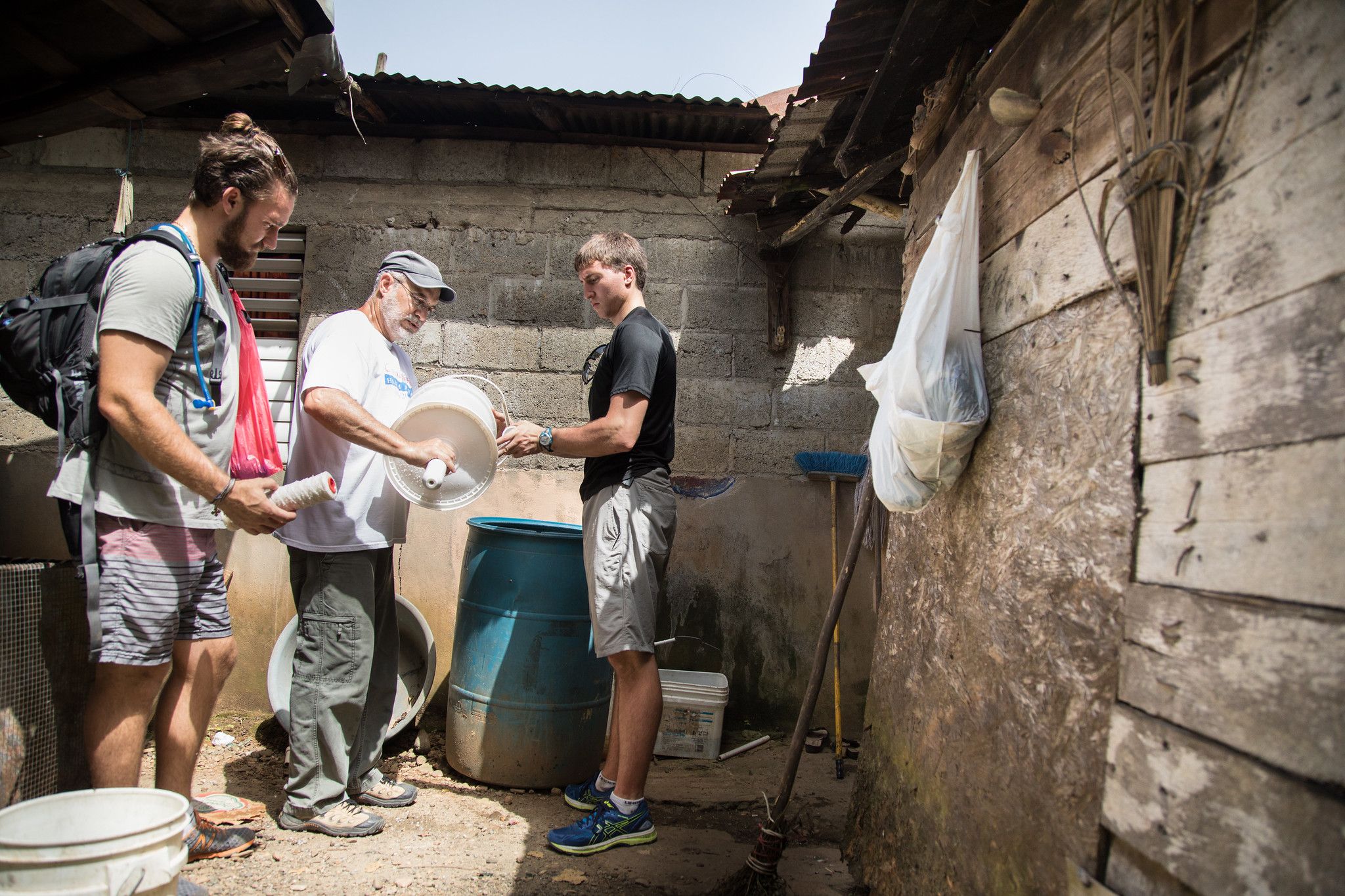 A professor and two students prep a water filtration system.