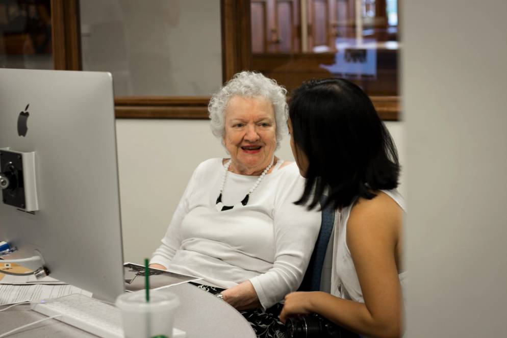 A student works with a resident from The Mayflower on a project about memory.