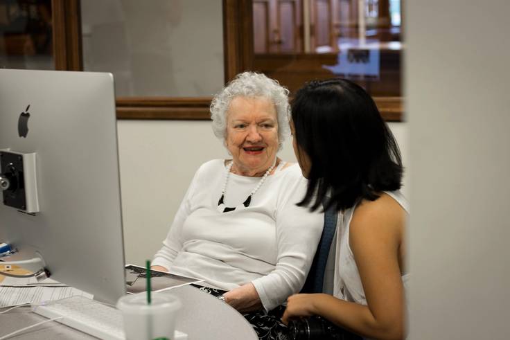 A student works with a resident from The Mayflower on a project about memory.