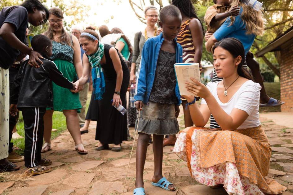 A Rollins student shows a younger student a book. 