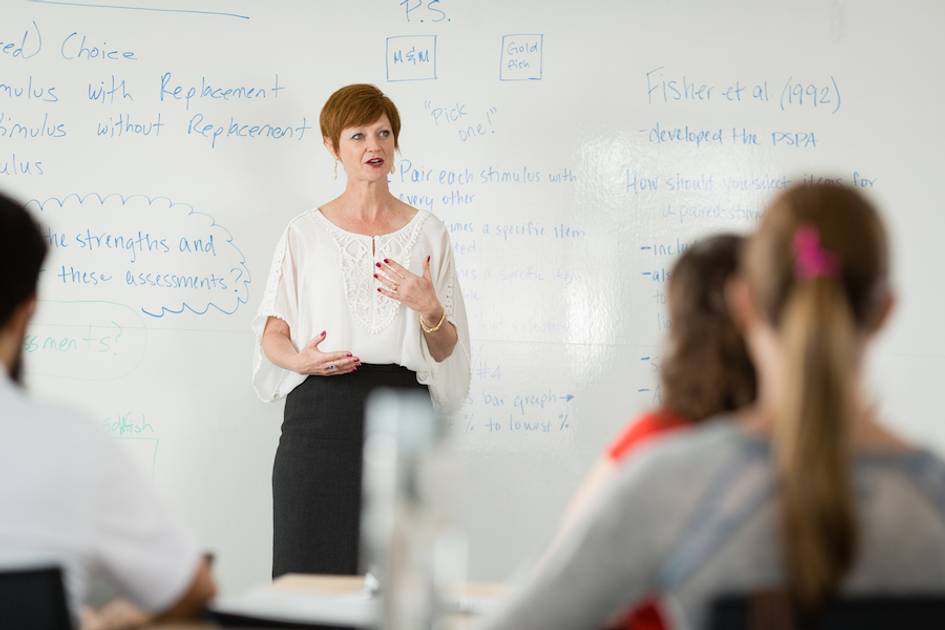 Woman professor speaking to a graduate class at Rollins College.