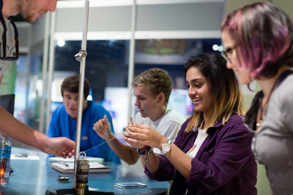 Students experiment with weights and measures as part of a physics course.