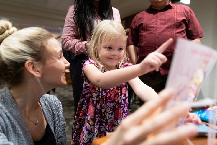 Rollins student reading a book to a child.