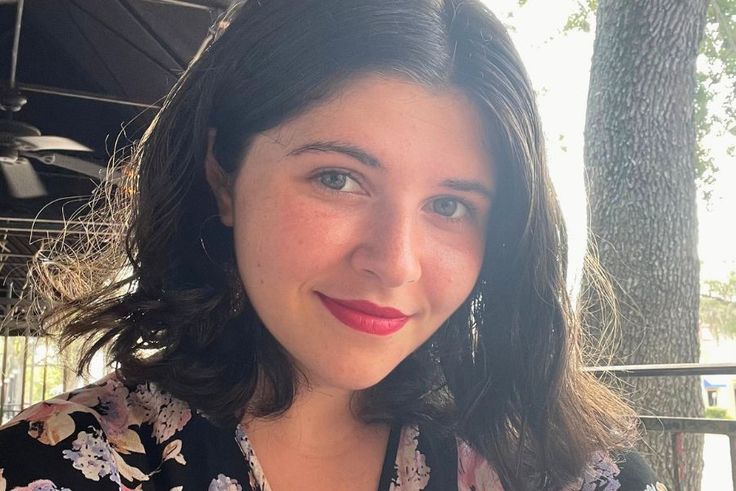 Evelyn Dietz ’28 with dark hair smiling outdoors at a shaded patio table