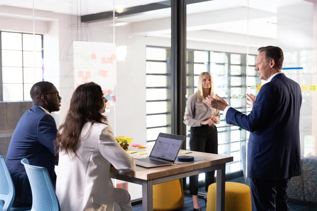 A business professor leads a brainstorm with three MBA students.