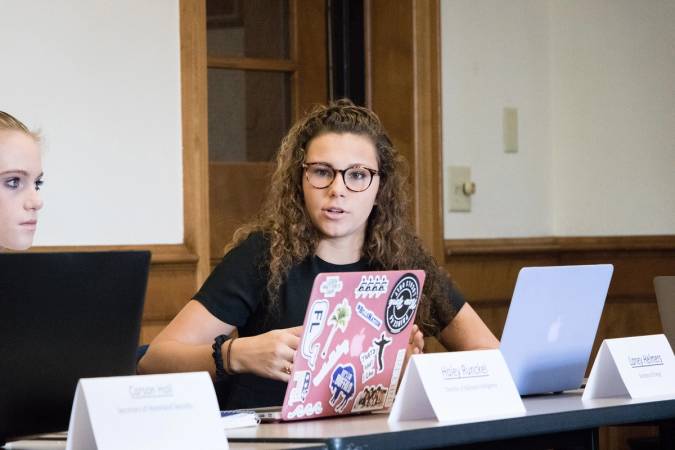 A college student sitting at her desk with computer talking about globalization policies.