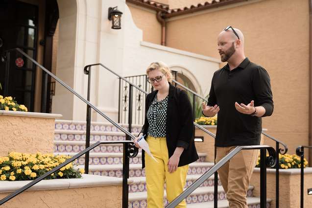 A college professor and student walking down the front colorful stairs of the Rice Family Pavilion.