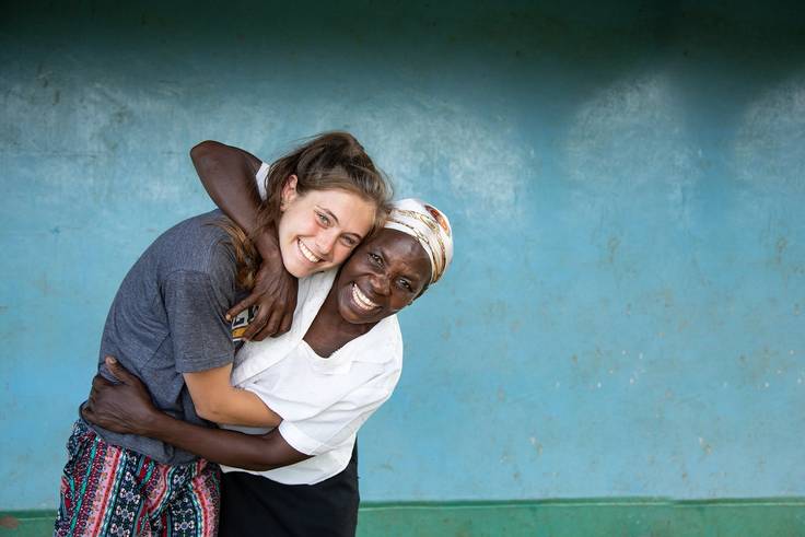 A student and a local Tanzanian embrace after forming a newfound connection.