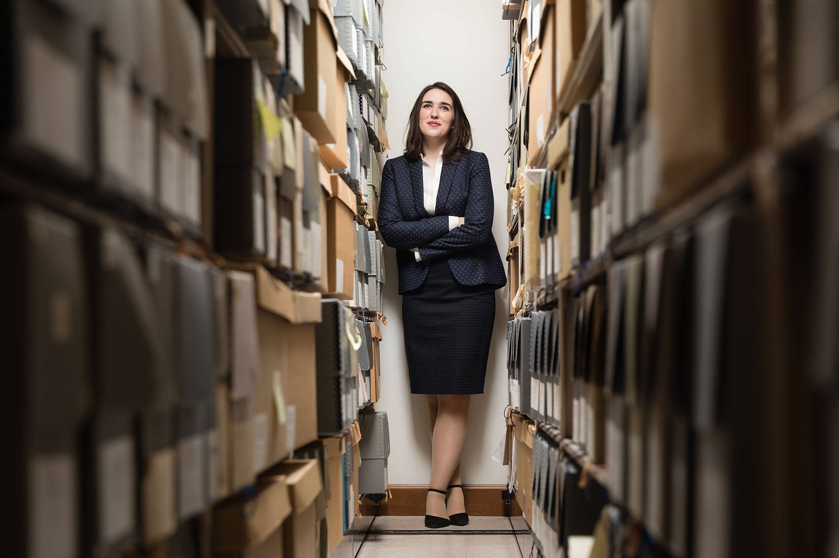 Rebecca Charbonneau ’16 portrait among boxes of art history archives and materials.