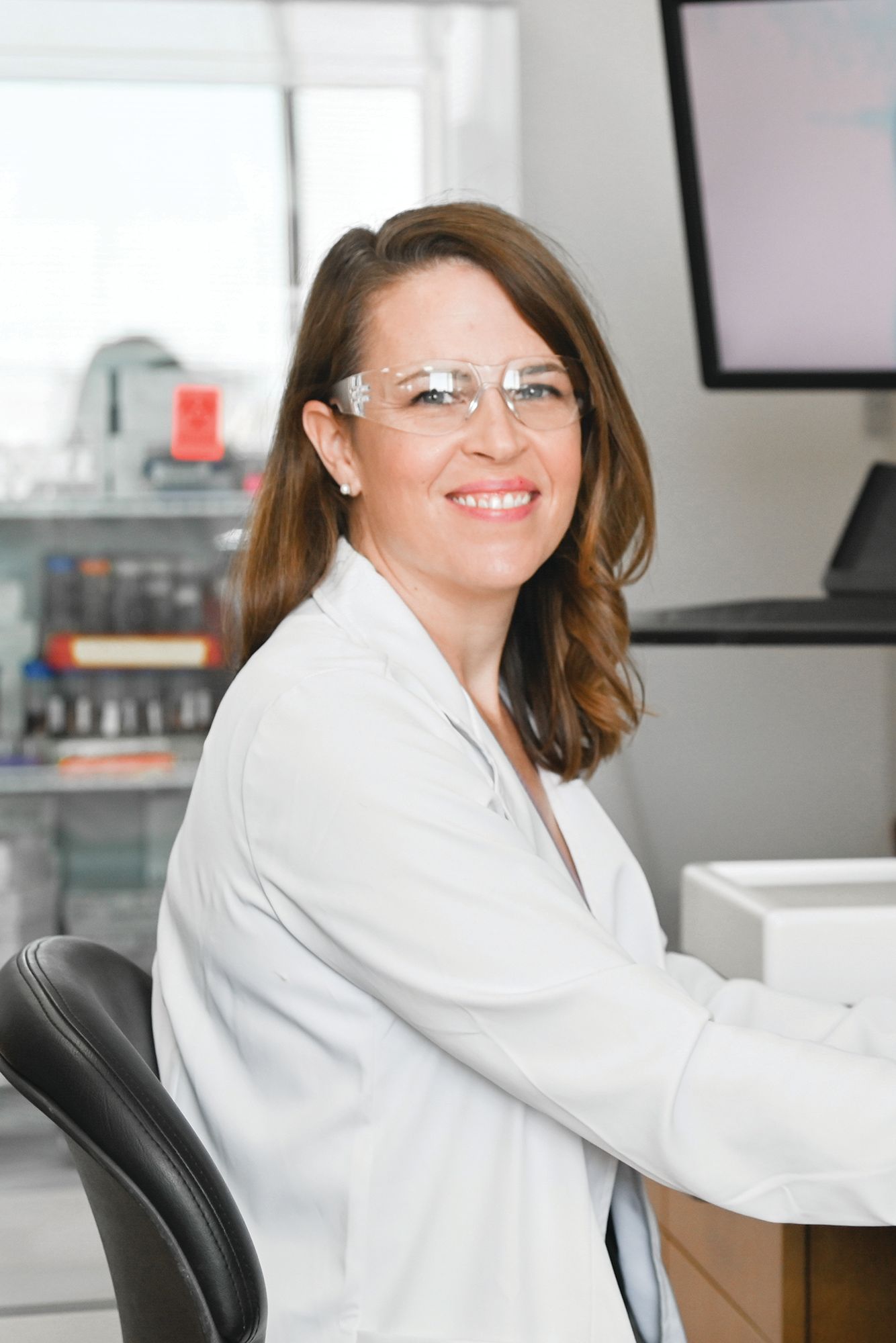 A public health professional poses for a portrait in a lab.