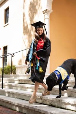 Marissa Cobuzio ’19 walks her service dog, Ari, down stairs on the Rollins campus.