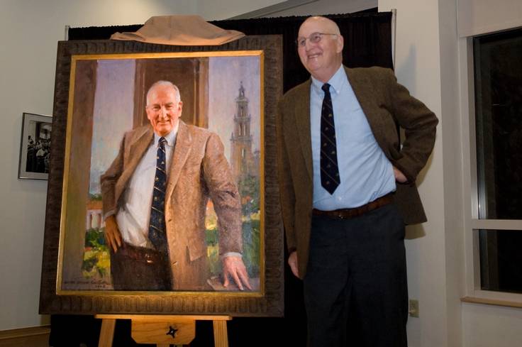 Thad Seymour pictured with his presidential portrait at Rollins College.