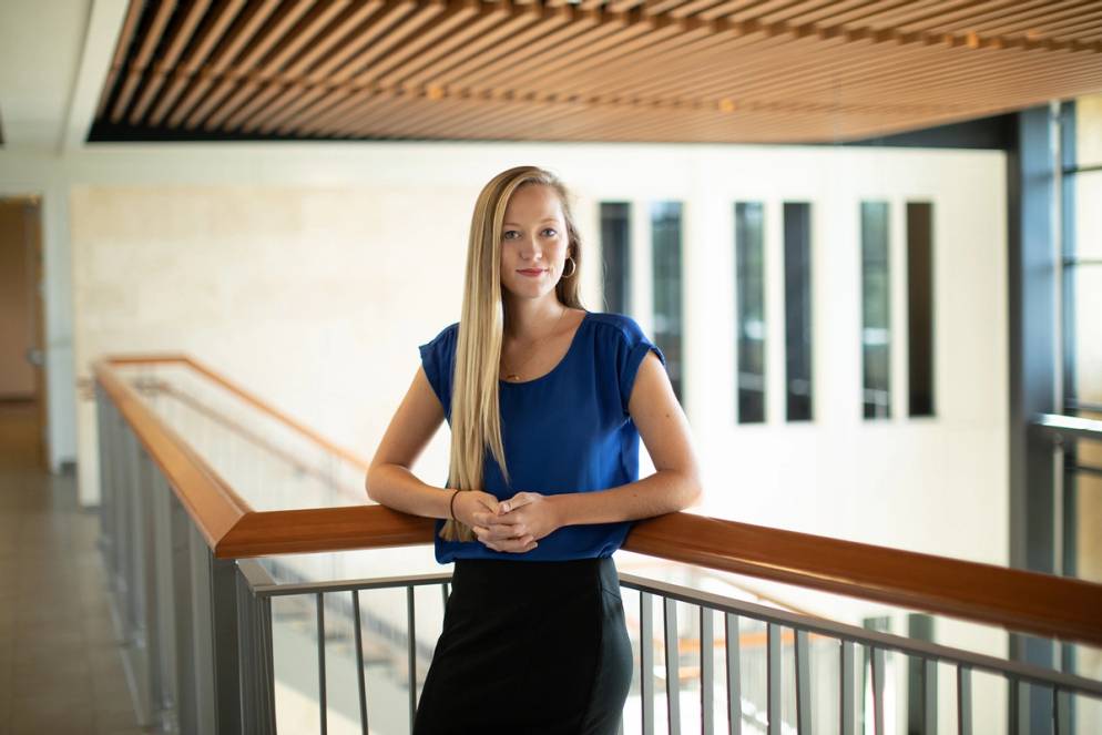 A college student poses for a portrait in the Bush Science Center.