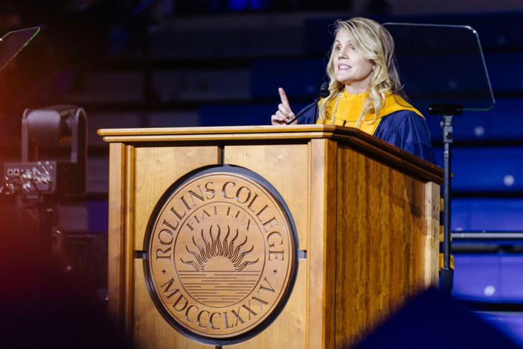 President Brooke Barnett giving her inaugural address at the podium with the Rollins College seal.