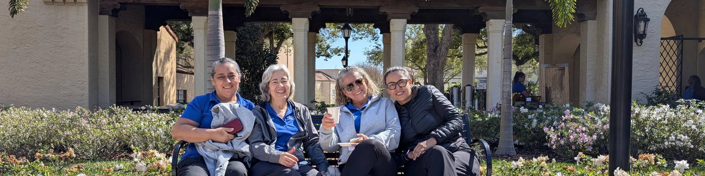 Rollins employees sit on bench at Rollins College.