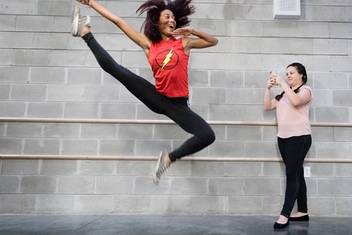 A social media intern snaps photos of a dancer.